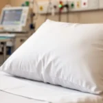 Miękka biała poduszka z delikatną teksturą tkaniny w otoczeniu sprzętu medycznego w szpitalu